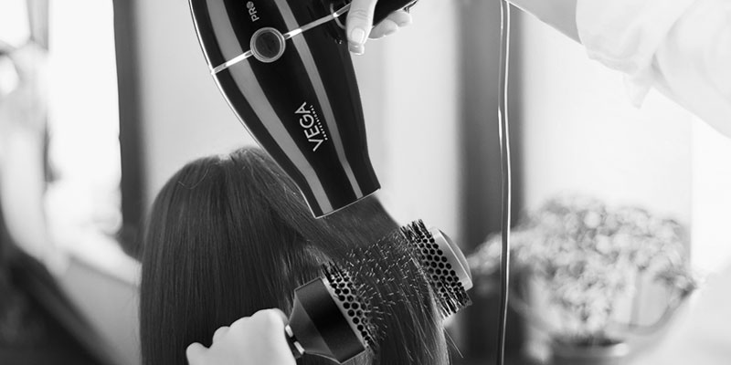 Hairdresser-creating-hairstyle-using-professional-hair-dryer